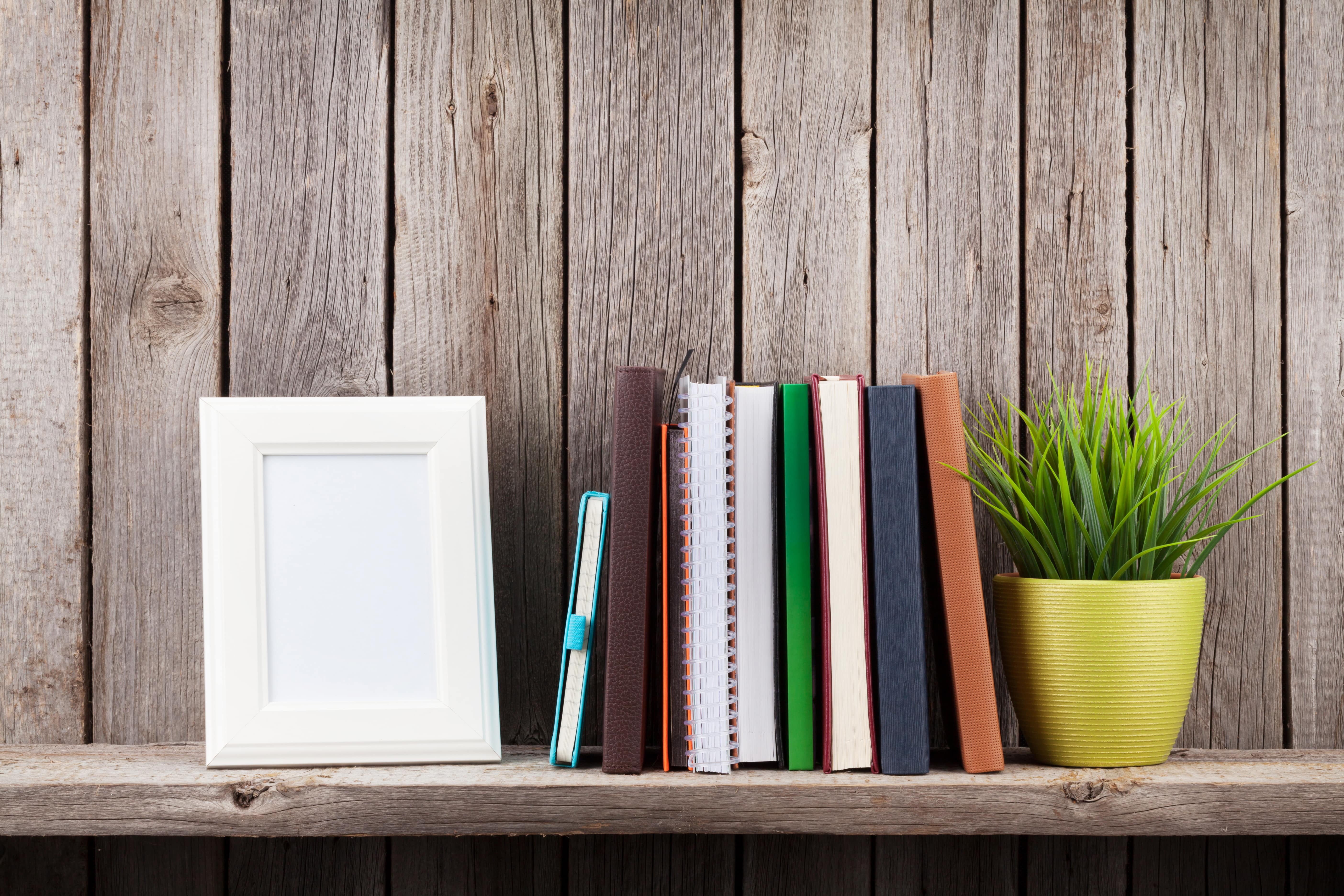 wooden-shelf-with-photo-frames-books-and-plant-PC7STDH-min